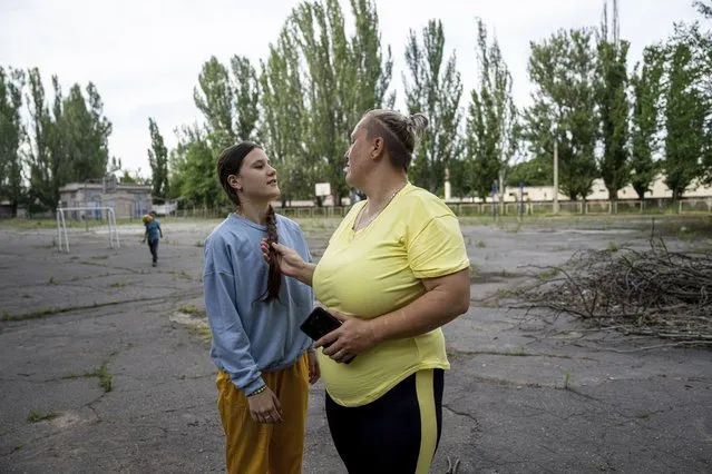 Yulia Valhe, right, speaks to her daughter Viktoria, in Kherson, Ukraine, Tuesday, June 13, 2023. Valhe, who was recently evacuated during the flooding from the Russian-occupied town of Oleshky, said “the Russian Federation provided nothing. No aid, no evacuation. They abandoned people alone to deal with the disaster”. (Photo by Evgeniy Maloletka/AP Photo)
