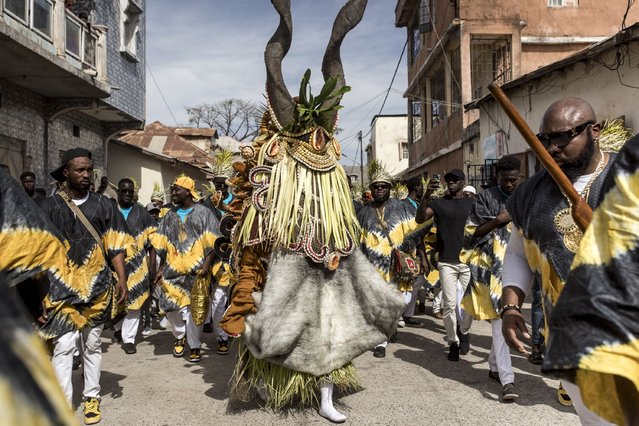 Members of the “Ekum Baba” light up the streets of Banjul ahead of the annual hunting festival in Banjul on January 1, 2025. Rooted in tradition, this vibrant celebration marks the New Year with music, dancing, and a fierce yet friendly competition between hunting societies for the title of the best display of animal heads, masks and costumes. (Photo by Muhamadou Bittaye/AFP Photo)