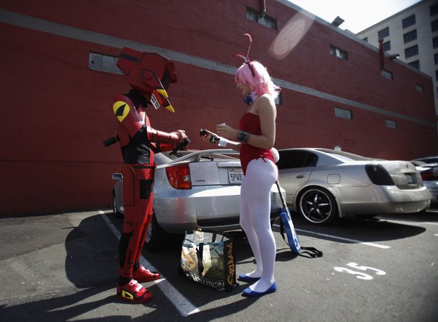 Attendees Emil Buenafe and Marisa Meyer finish up getting ready in their costumes of “Canti” and “Haruko” from the animated series “FLCL” during the Comic Con International convention in San Diego, California July 13, 2012. (Photo by Mario Anzuoni/Reuters)