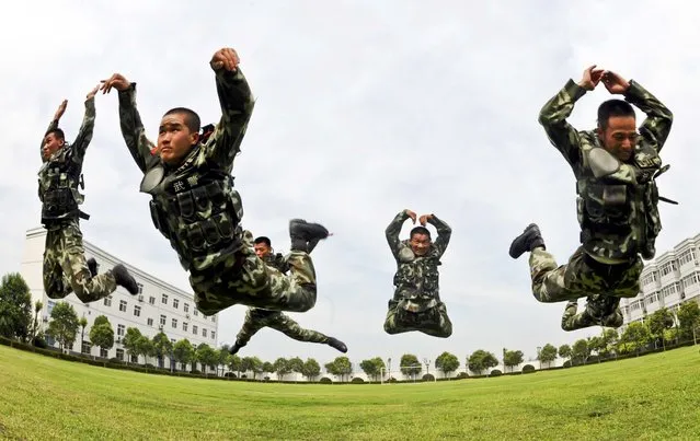 Paramilitary policemen jump as they practice during a summer drill in Bozhou, Anhui province, on July 26, 2013. (Photo by Reuters/China Daily)