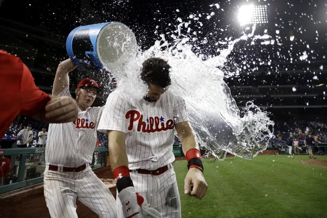 Philadelphia Phillies' Trevor Plouffe, center, is doused by Rhys Hoskins after Plouffe's game-winning three-run home run off Los Angeles Dodgers relief pitcher k*ke Hernandez during the 16th inning of a baseball game, early Wednesday, July 25, 2018, in Philadelphia. Philadelphia won 7-4. (Photo by Matt Slocum/AP Photo)