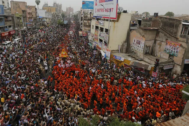 Indian Hindu devotees participate in the annual festival of Rath Yatra, or chariot procession, in Ahmadabad, India, Saturday, July 14, 2018. The three idols of Hindu God Jagannath, his brother Balabhadra and sister Subhadra are taken out in a grand procession in specially made chariots called raths, which are pulled by thousands of devotees on this day. (Photo by Ajit Solanki/AP Photo)