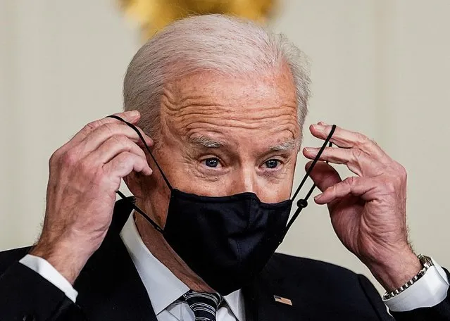 U.S. President Joe Biden replaces his face mask after delivering remarks on the implementation of the American Rescue Plan in the State Dining Room at the White House in Washington, U.S., March 15, 2021. (Photo by Kevin Lamarque/Reuters)