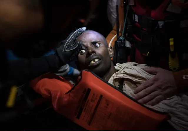 Members of MOAS (Migrant Offshore Aid Station) and the Red Cross try to keep a man alive, who it was believed was suffering after breathing fumes from a boat engine he was travelling on on November 21, 2016 in Pozzollo Italy. The MOAS team worked through the night and into the next morning rescuing “approximately” 600 people from vessels. MOAS are currently patrolling international waters off the coast of Libya, and running rescue missions for the many migrants and refugees who continue to attempt to make the dangerous crossing across the Mediterranean Sea to Italy. MOAS are a Malta based registered foundation dedicated to providing professional search-and-rescue assistance to refugees and migrants in distress at sea and work alongside with the Red Cross on board the Topaz Responder. The number of deaths this year of people crossing the Mediterranean has risen to almost 4,300. MOAS alone have rescued around 19,000. (Photo by Dan Kitwood/Getty Images)