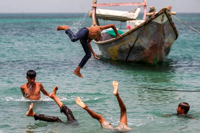 A boy jumps into the Red Sea near Yemen's port of Ras Issa in the contested western province of Hodeida on June 12, 2023. (Photo by Mohammed Huwais/AFP Photo)