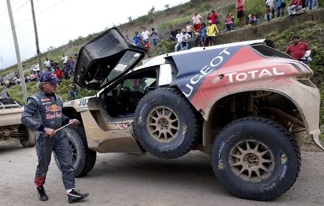 Carlos Sainz of Spain walks next to his Peugeot as he arrives at the bivouac at the end of the fourth stage in the Dakar Rally 2016 in Jujuy province, Argentina, January 6, 2016. (Photo by Marcos Brindicci/Reuters)