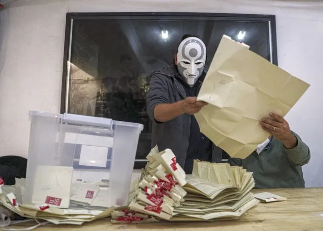 An electoral worker with a mask of the Amon character of the Legend of Korra animated series counts ballots after the second day of the Constitutional Convention election to select assembly members that will draft a new constitution, in Santiago, Chile, Sunday, May 16, 2021. The South American country is choosing 155 people to draft a constitution to replace one that has governed it since being imposed during a military dictatorship. (Photo by Esteban Felix/AP Photo)