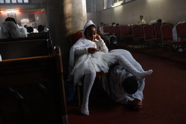 A young girl uses her father as a footstool as members of the Ethiopian community take part in a joint celebration of Meskel, and the restitution of a sacred Tabot, at the Ethiopian Orthodox Church of St Mary, on September 30, 2023 in London, England. The Tabot, which was looted by British Troops at the battle of Maqdala 155 years ago, has returned to London's Ethiopian Community before it's eventual return to Ethiopia. The Tabots' private restitution comes after being seen for sale online by Jacopo Gnisci, a University College London lecturer, which he bought for the purpose of its return to Ethiopia. The event ties in with the annual Ethiopian Meskel celebration, a religious holiday in the Ethiopian Orthodox church that commemorates the discovery of the True Cross in the fourth century by the Roman Empress Helena. (Photo by Dan Kitwood/Getty Images)