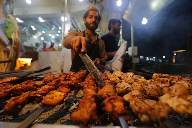 A man sells roasted chicken on a road on the eve of World Food Day in Peshawar, Pakistan, 15 October 2018. World Food Day is celebrated every year on 16 October to commemorate the founding of the Food and Agriculture Organization of the United Nations (FAO) in 1945. World Food Day aims to heighten public awareness of the plight of the world's hungry and malnourished and to encourage people worldwide to take action against hunger. (Photo by Arshad Arbab/EPA/EFE)