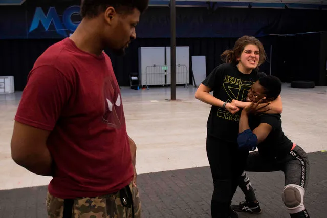 Months before she would become the youngest female champion ever, professional wrestler Gia Scott (R) gets pointers from her boyfriend and professional wrestler Deion Epps (L) as she wrestles with fellow female wrestler Aria Palmer (C) during a class in Joppa, Maryland on April 17, 2018, at the MCW Wrestling school that teaches a budding wrestler the ins and outs of the industry. When we meet Gia Scott, it is hard to imagine that, for her work, this polite and warm girl likes to insult, assault and provoke. And yet, Gia is a professional wrestler specializing in “naughty” roles. With some success. (Photo by Jim Watson/AFP Photo)