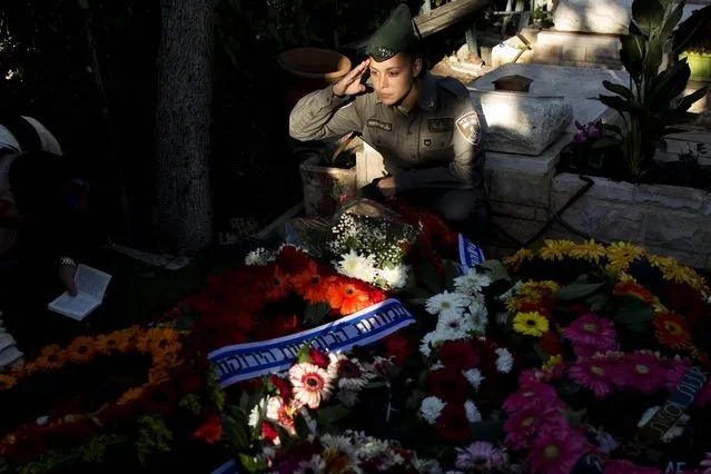 An Israeli border policewoman salutes next to the grave of Israeli border policewoman Hadar Cohen, 19, during her funeral at the military cemetery in the city of Yehud, Israel, 04 February 2016. Hadar Cohen was killed a day before at Jerusalem's Damascus Gate during  a confrontation with three Palestinian attackers, who opened fire and stabbed Israeli border policewomen at the Damascus Gate into Jerusalem's walled Old City. (Photo by Abir Sultan/EPA)