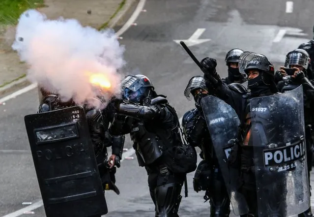 Riot police members fire tear gas during a student protest in rejection of the government of President Ivan Duque, in Bogotá on August 4, 2022. (Photo by Juan Pablo Pino/AFP Photo)