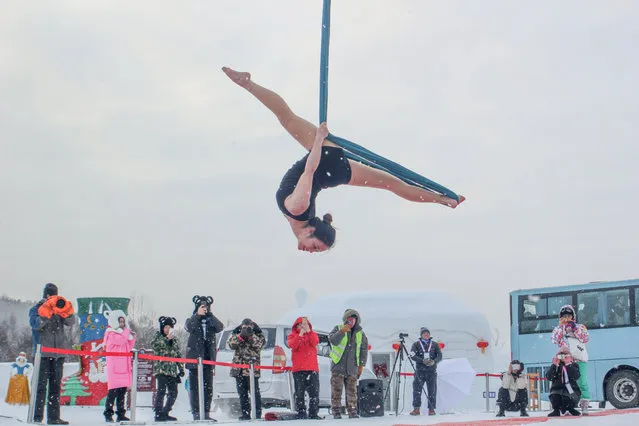 People take pictures of a participant taking part in a pole dancing contest in subzero temperatures, in Mohe, Heilongjiang province, China December 21, 2018. (Photo by Reuters/China Stringer Network)
