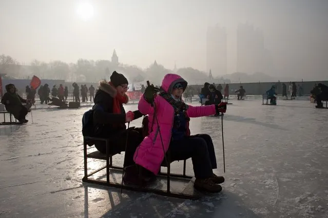 People enjoy the frozen riverbank in Harbin on January 5, 2017. (Photo by Nicolas Asfouri/AFP Photo)