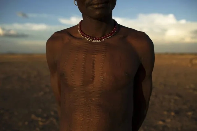 Ngimalia Ilete, the leader of a Turkana cattle kraal shows his traditional scars, which prove that he his an able warrior who has killed enemies in the past, in the disputed area of the Ilemi triangle of northwestern Kenya near the borders with Ethiopia and South Sudan October 14, 2013. (Photo by Siegfried Modola/Reuters)