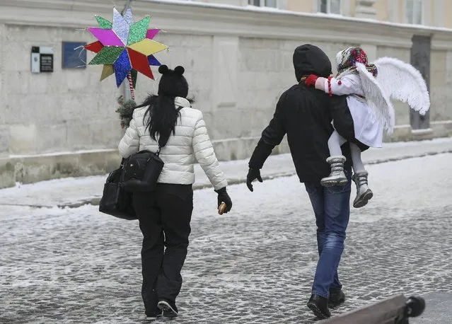 A couple walks with their child during the eve of the Orthodox Christmas celebrations in Lviv, Ukraine, January 6, 2017. (Photo by Gleb Garanich/Reuters)