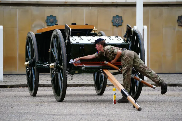 A member of the military cleans a Gun Carriage of The Kings Troop Royal Horse Artillery as they make their final preparations at Wellington Barracks in central London on September 14, 2022, before taking part in ceremonial procession of the coffin of Queen Elizabeth II, from Buckingham Palace to Westminster Hall. Queen Elizabeth II will lie in state in Westminster Hall inside the Palace of Westminster, from Wednesday until a few hours before her funeral on Monday, with huge queues expected to file past her coffin to pay their respects. (Photo by Ben Birchall/Pool via AFP Photo)