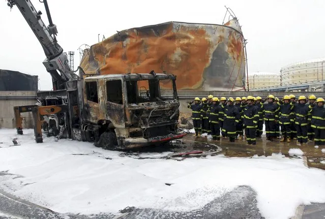 Firefighters salute to a burnt-out firefighter truck after they extinguished a fire at a petrochemical plant in Zhangzhou, Fujian province April 9, 2015. (Photo by Reuters/Stringer)
