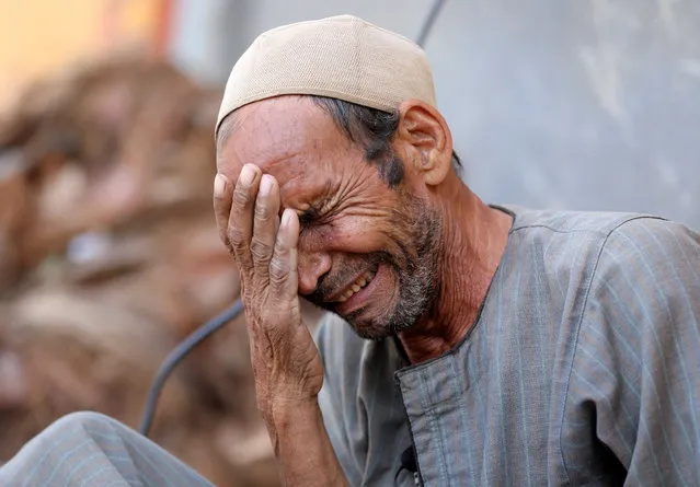 Hassan El Salheen, weeps after burying the repatriated body of his son, Aly, who died along with his three cousins in Libya after Storm Daniel hit the country, at Al Sharief village in Bani Swief province, Egypt on September 13, 2023. (Photo by Mohamed Abd El Ghany/Reuters)