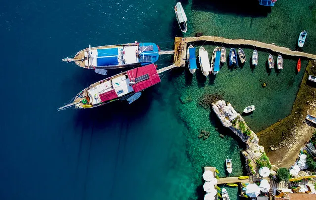 A drone photo shows a sea port with boats through the Ucagiz port, known as Teimiusa, that belongs to Myra Ancient City in Antalya, Mediterranean coast of Turkey on July 25, 2018. Antalya is one of the most outstanding tourist attraction cities all over the world in terms of cultural, sea, sports, health, winter, congress, plateau, cave, camp and belief tourism. The Myra City has been in existence since 5th century B.C. with Lycian period rock tombs, Roman period theater. (Photo by Mustafa Ciftci/Anadolu Agency/Getty Images)