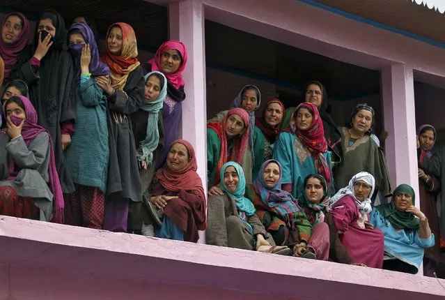 Kashmiri women weep as they watch the funeral procession of Mushatq Ahmad Wani, an Indian policeman, during his funeral in Arigam, south of Srinagar April 6, 2015. (Photo by Danish Ismail/Reuters)
