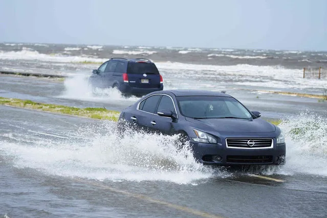 Cars drive through flood waters along route 90 as outer bands of Hurricane Ida arrive Sunday, August 29, 2021, in Gulfport, Miss. (Photo by Steve Helber/AP Photo)