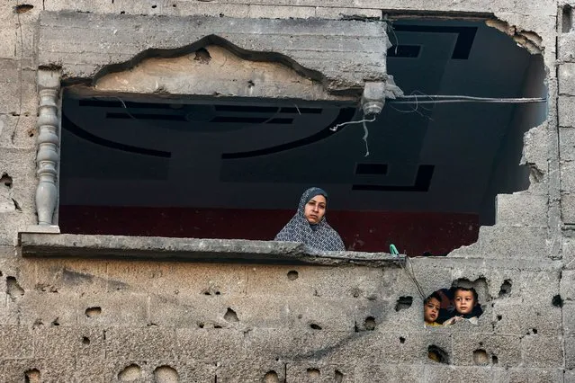 A Palestinian woman and children looks on following Israeli bombardment on Rafah, in the southern Gaza Strip, on December 15, 2023, amid continuing battles between Israel and the Palestinian militant group Hamas. (Photo by Mohammed Abed/AFP Photo)