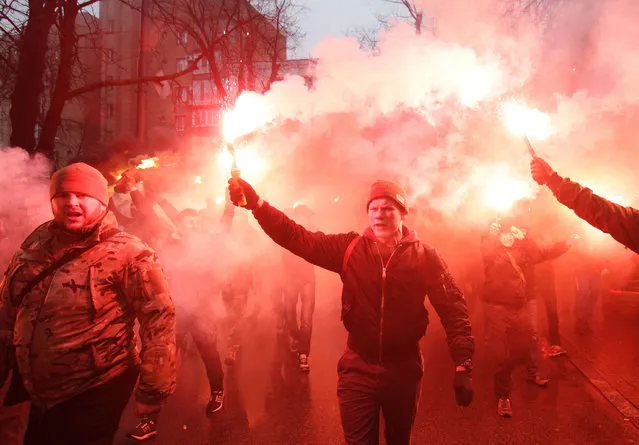 Members of the Ukrainian volunteer battalion Azov hold flares during a protest outside the Ukrainian Security Services (SBU) prison in Kiev on March 1, 2016.
The protesters are demanding the release of Stanislav Krasnov, head of the nationalist organisation “Azov-Crimea”, who is accused of spying for Russia. (Photo by Anatolii Stepanov/AFP Photo)