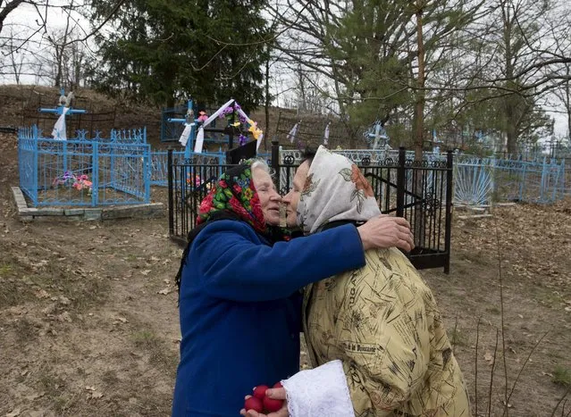 Belarussian women meet at a cemetery during “Radunitsa”, or the Day of Rejoicing, a holiday in the Eastern Orthodox Church to remember the dead, in the abandoned village of Orevichi, near the exclusion zone around the Chernobyl nuclear reactor, southeast of Minsk, April 21, 2015. (Photo by Vasily Fedosenko/Reuters)