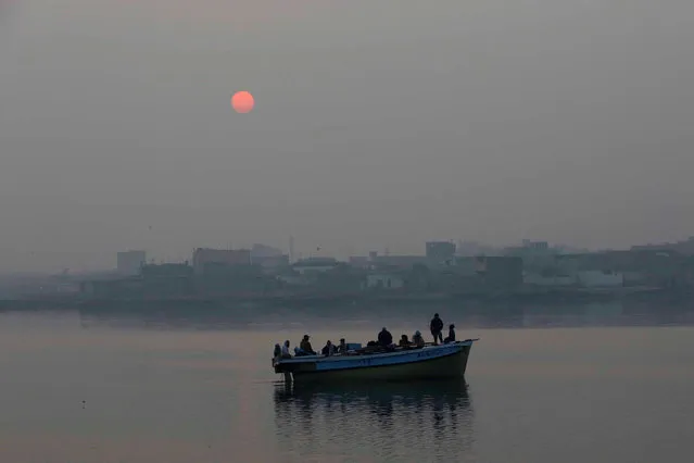 Men travel in a boat against the backdrop of a rising sun, as they return from fishing early morning in Karachi, Pakistan, January 1, 2017. (Photo by Akhtar Soomro/Reuters)