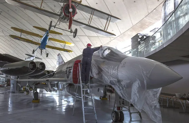 A volunteer covers a F-4 after cleaning it inside the newly refurbished “American Hanger” at the Imperial War Museum in Duxford on February 24, 2016 in Duxford, England. The American Hanger at the Imperial War Museum in Duxford is to re-open to the public in the Spring after major refurbishment work. (Photo by Dan Kitwood/Getty Images)