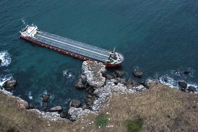 In an aerial view, a cargo ship with 20 tons of fuel on board is stranded in rocky shore on September 21, 2021 in Kamen Bryag, Bulgaria. There is 20 tons of fuel on board the stranded ship near Kamen Bryag, which is transporting granular fertilizers (2,800 tons of urea). There is no danger of pollution of the sea, as the ship's crew and its tanks in which its fuel is stored are intact. A diving group is expected to inspect the hull before proceeding with the withdrawal of the vessel. (Photo by Hristo Rusev/Getty Images)