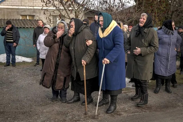 Relatives mourn during the funeral Dmytro Kononets, 26, a soldier in training who was killed in May during a Russian missile strike on a military training center, in Kyiv, Ukraine on Thursday, December 29, 2022. Explosions rocked towns and cities around Ukraine on Thursday morning and electricity went out in several regions as Russia launched what appeared to be one its biggest strikes to date on the country’s energy grid. (Photo by Nicole Tung/The New York Times)
