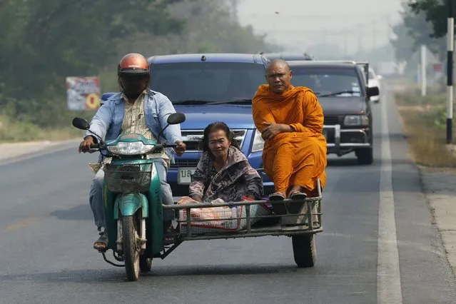 A Buddhist monk rides a motorcycle sidecar on a road in Ratchaburi province, outside Bangkok, Thailand on March 22, 2016. (Photo by Jorge Silva/Reuters)