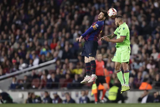 Barcelona forward Lionel Messi, left, jumps for the ball with Levante's Ruben Vezo during a Spanish La Liga soccer match between FC Barcelona and Levante at the Camp Nou stadium in Barcelona, Spain, Saturday, April 27, 2019. (Photo by Manu Fernandez/AP Photo)