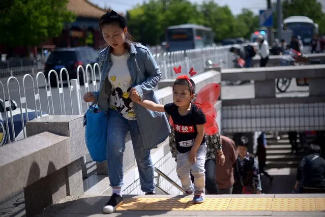 A family walks out of an underpass near the Forbidden City in Beijing on May 3, 2015. (Photo by Wang Zhao/AFP Photo)