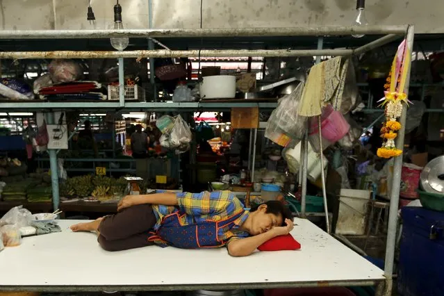 A vendor takes a nap at her stall at a market in Bangkok, Thailand March 31, 2016. (Photo by Jorge Silva/Reuters)