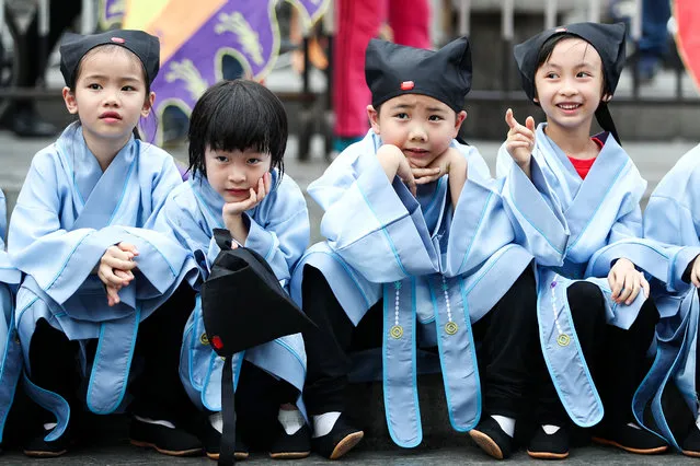Pre-primary school kids attend First Writing Ceremony with Confucian-style Han clothes at Liziwan Creek on April 8, 2019 in Guangzhou, China. The First Writing Ceremony, also known as the Enlightenment Ceremony, is an important observance for students before they are admitted to school to receive education in China. During the ceremony, teachers place a red dot on each child’s forehead, signifying the opening of wisdom’s eye, in Chinese traditional culture.(Photo by Zhong Zhi/Getty Images)