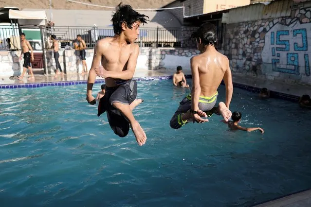Boys jump into a swimming pool at the Jaref Valley hot natural water baths on the outskirts of Sanaa, Yemen on November 12 , 2021. (Photo by Khaled Abdullah/Reuters)