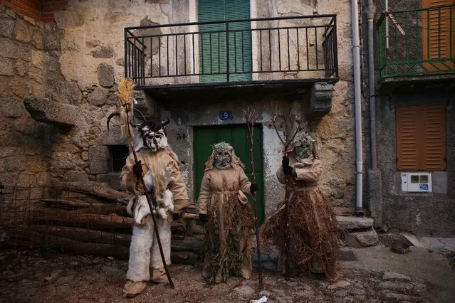 Mariano Casillas (L), his wife Marta Vega and his sister Cristina Casillas pose dressed as the traditional carnival characters “Harramachos”, who wear cowbells, animal antlers and agricultural decor and are thought to ward off evil spirits and awaken the coming spring, during a carnival celebration in the village of Navalacruz, Spain, February 25, 2017. (Photo by Susana Vera/Reuters)