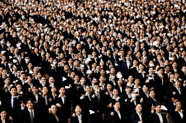 Newly hired employees of Japan Airlines (JAL) group fly paper planes during the company group's initiation ceremony at a hangar of Haneda Airport in Tokyo, Japan, on April 1, 2024. (Photo by Issei Kato/Reuters)