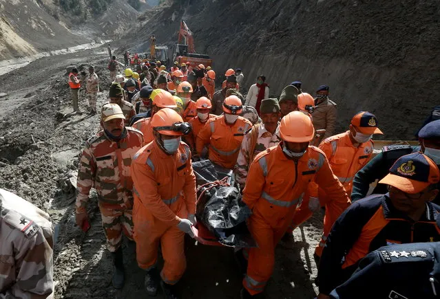Members of National Disaster Response Force (NDRF) carry the body of a victim after recovering it from the debris during a rescue operation outside a tunnel after a part of a glacier broke away, in Tapovan in the northern state of Uttarakhand, India, February 9, 2021. (Photo by Reuters/Stringer)