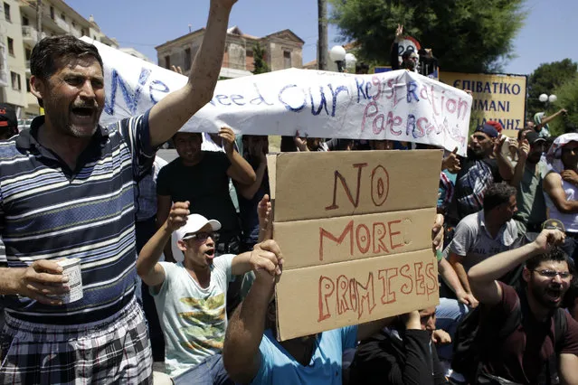 Syrians shout slogans during a protest by refugees and migrants, demanding better living conditions and faster processing of their asylum registrations at the port of Mytilene, on the northern Greek island of Lesvos on Wednesday, June 17, 2015. The Aegean island has borne the brunt of a huge influx of migrants from the Middle East, Asia and Africa crossing from Turkey to nearby Greek islands. More than 50,000 migrants have arrived in Greece so far this year. (AP Photo/Thanassis Stavrakis)