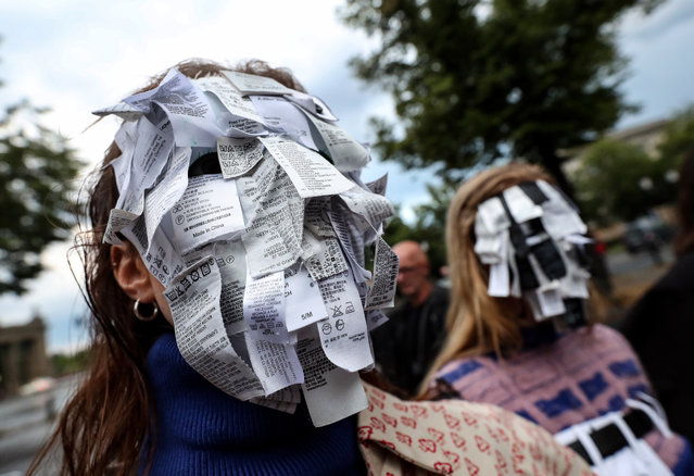 Models masked with cotton labels wait to step on the catwalk during the open air fashion show SCHAU19 in Berlin, Germany, 13 July 2019. The show produced by students is part of the fashion design study program of the Berlin University of Arts. (Photo by Felipe Trueba/EPA/EFE)