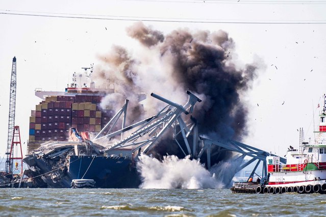 Crews conduct a controlled demolition of a section of the Francis Scott Key Bridge resting on the Dali container ship in Baltimore on May 13, 2024. The Francis Scott Key Bridge, a major transit route into the busy port of Baltimore, collapsed on March 26 when the Dali container ship lost power and collided into a support column, killing six roadway construction workers. (Photo by Roberto Schmidt/AFP Photo)