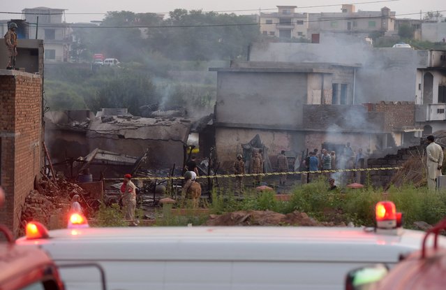 Soldiers and other personnel work at the scene where a Pakistani Army Aviation Corps aircraft crashed in Rawalpindi on July 30, 2019. Fifteen people were killed when a small plane crashed into a residential area in the Pakistani city of Rawalpindi near the capital Islamabad, a rescue official told AFP early July 30. (Photo by Aamir Qureshi/AFP Photo)