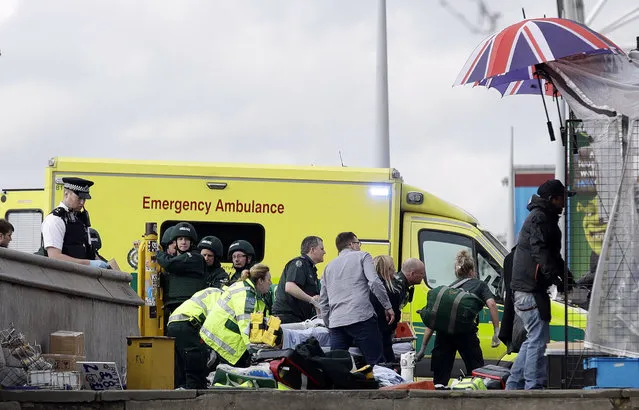 Emergency services staff provide medical attention close to the Houses of Parliament in London, Wednesday, March 22, 2017. (Photo by Matt Dunham/AP Photo)