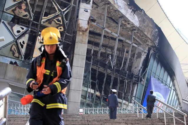 Rescue workers stand outside the site where a fire broke out at the Shanghai Hongkou soccer stadium in Shanghai, China March 28, 2017. (Photo by Aly Song/Reuters)