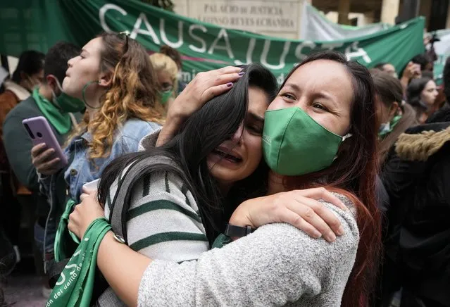 Abortion-rights activists celebrate after the Constitutional Court approved the decriminalization of abortion, lifting all limitations on the procedure until the 24th week of pregnancy, in Bogota, Colombia, Monday, February 21, 2022. (Photo by Fernando Vergara/AP Photo)