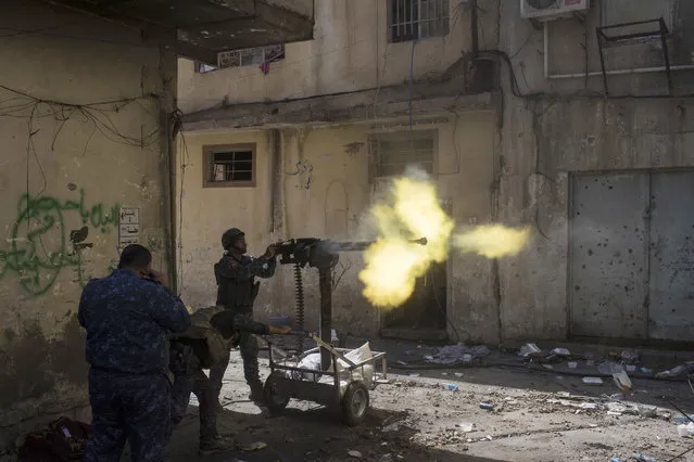 Federal policemen fire towards Islamic State positions in the old city during fighting on the western side of Mosul, Iraq, Thursday, March 30, 2017. (Photo by Felipe Dana/AP Photo)